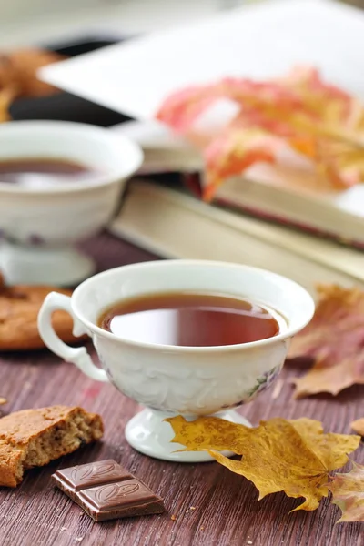 Estilo de vida otoñal con té caliente, dulces y hojas amarillas — Foto de Stock