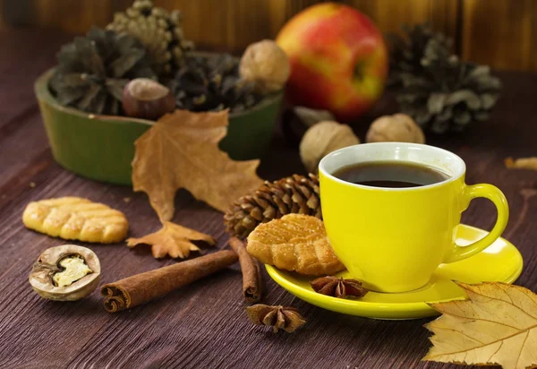 Осенний стиль жизни с горячим чаем, сладостями, орехами и желтыми листьями — стоковое фото