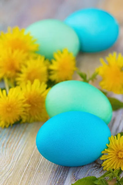 Huevos de Pascua y flores sobre fondo de madera — Foto de Stock