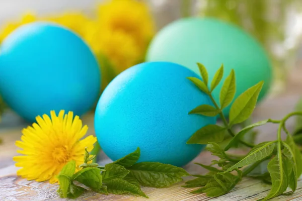 Huevos de Pascua y flores sobre fondo de madera — Foto de Stock