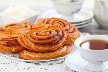 Bardak çay ile pişmiş tatlı tarçın rulo