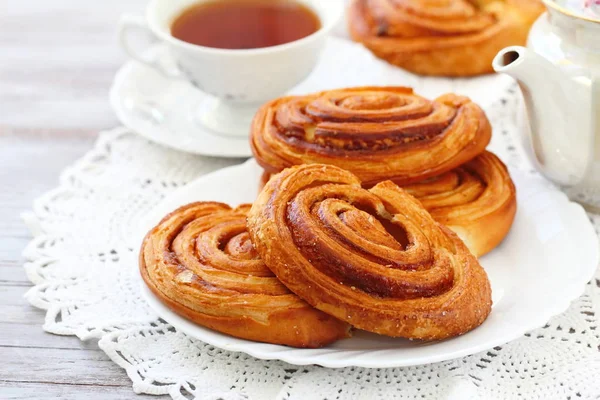 Baked sweet cinnamon rolls with cup of tea — Stock Photo, Image