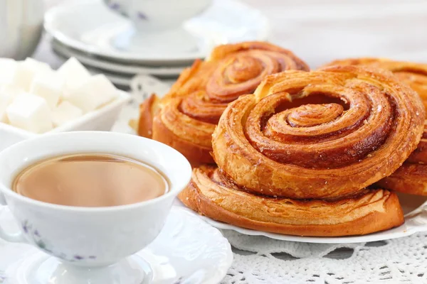 Baked sweet cinnamon rolls with cup of tea — Stock Photo, Image