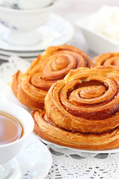 Baked sweet cinnamon rolls with cup of tea — Stock Photo, Image