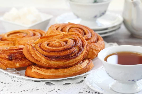 Baked sweet cinnamon rolls with cup of tea — Stock Photo, Image