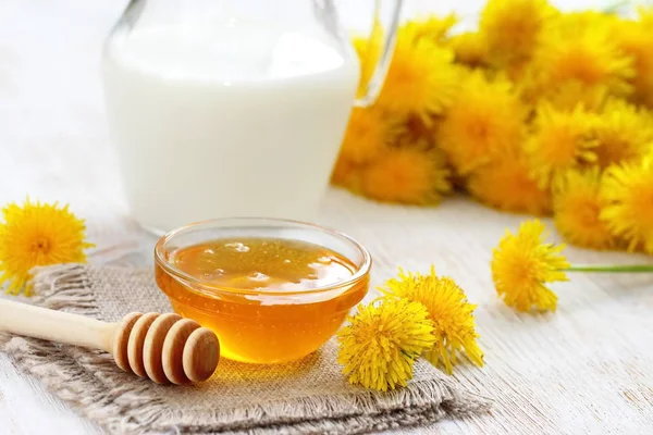 Цветочный мед в стеклянной чаше и молоке — стоковое фото