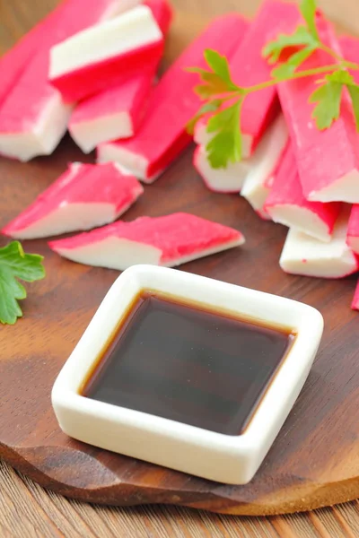 Soy sauce in a square bowl and crab sticks Stock Photo