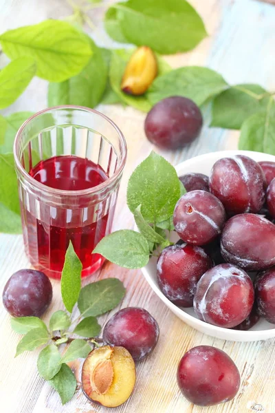 Свежий фруктовый сок и красные сливы — стоковое фото