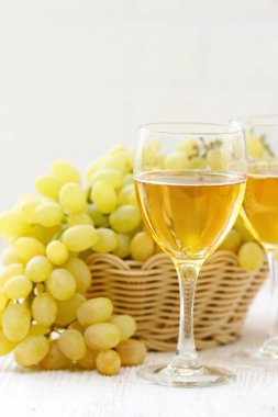 Kadeh şarap ve üzüm sepeti ahşap bir masa üzerinde... Yeni hasat. Tatma.