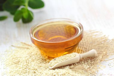 Bardakta susam yağı ve masada tohum