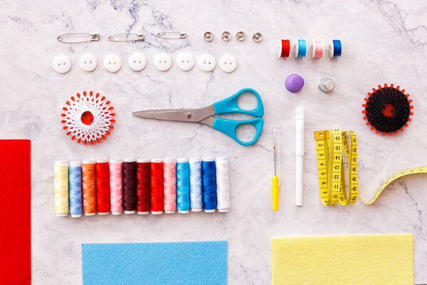 colorful sewing and tailoring tools and items on light backgroun