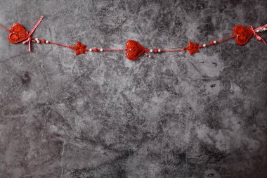 Siyah arka planda kırmızı metal kalpler. Sevgililer Günü çelengi.