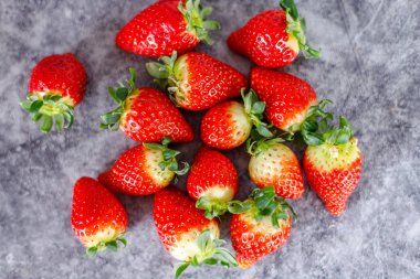 Koyu arka planda bir sürü taze kırmızı çilek. Sağlıklı kırmızı rıhtım