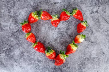 Koyu arka planda bir sürü taze kırmızı çilek. Sağlıklı kırmızı rıhtım