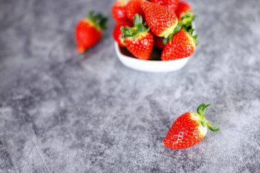 Koyu arka planda bir sürü taze kırmızı çilek. Sağlıklı kırmızı rıhtım