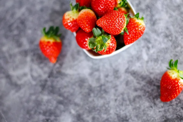 Många färska röda jordgubbar på mörk bakgrund. Friska röda berr — Stockfoto