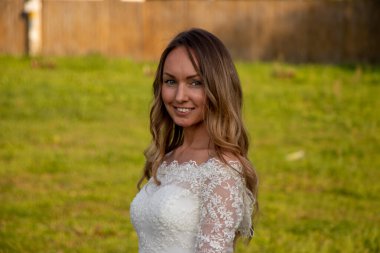 Genç gelinin portresi çimenlikte yeşil çimlerle.