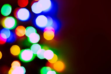 Parlak ve renkli ışık lekeleri. Kamera ve lens bokeh. Noel perisi LED ışıkları bulanık bir etki yaratıyor. Tasarım için arkaplan.