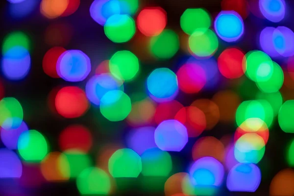 Glowing and festive colored light spots. In camera and lens bokeh. Christmas fairy LED lights defocused giving a blurred effect. Background for design.