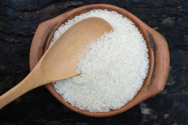 Saque el arroz utilizando un cucharón en una olla de barro — Foto de Stock