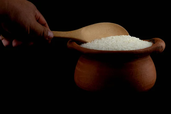 Saque el arroz utilizando un cucharón en una olla de barro — Foto de Stock