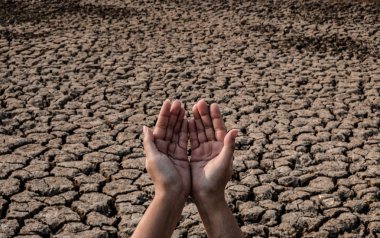 Kadın eli yağmur suyu için bekliyor, çorak ve kuru toprak.