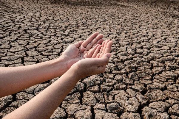 Señora mano esperando por el agua de lluvia, suelo agrietado y seco en ar árido — Foto de Stock