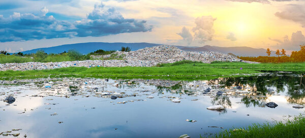 Загрязненная вода и большая горная куча мусора и загрязнение
