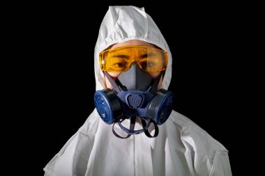 Kimyasal koruyucu giysiler ve camlı antigaz maskeli bir kadın.