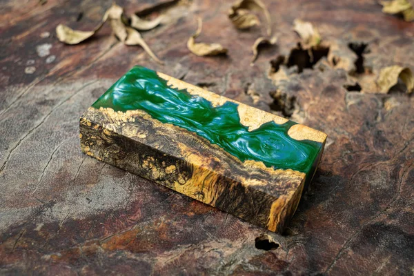 Casting green epoxy resin burl wood cube on old table art backgr — 스톡 사진