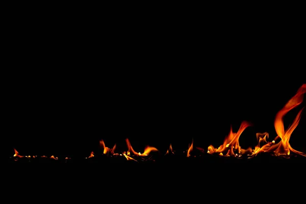Em chamas de fogo no fundo preto — Fotografia de Stock