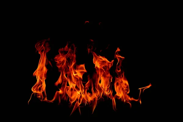 Στις φλόγες της φωτιάς στο μαύρο φόντο — Φωτογραφία Αρχείου