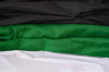 Kumaş dalgaları arkaplanı kapatır, Katlanmış kumaş 3 renk siyah yeşil beyaz, zarif duvar kağıdı tasarımı, grunge ipek desenli saten kadife kumaş kıvrımları