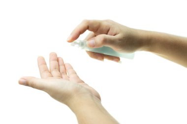 Beyaz arka plan, sağlık ve vücut bakımı ve kişisel hijyen konseptindeki mikropların yayılmasını önlemek için plastik şişeden ya da bakteriye karşı alkol spreyi kullanan kadının eli.