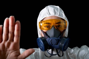 Beyaz arka planda gözlüklü kimyasal koruyucu giysili ve antigaz maskeli bir kadın güvenlik kıyafeti giymiş kadın bilim adamı, güvenlik virüsü enfeksiyonu konsepti.