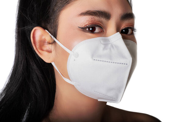 Close up of a woman putting on a respirator N95 mask to protect from airborne respiratory diseases as the flu covid-19 coronavirus ebola PM2.5 dust and smog, Safety virus infection concept