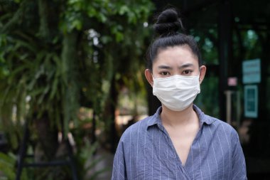 Solunum maskesi takan genç Asya 'lı kadına yakından bakın. Solunum yolu N95 maskesi takarak gripten korunuyor. Cauvid-19 Coronavirus ebola PM2.5 tozu ve yollarda oluşan duman gibi.