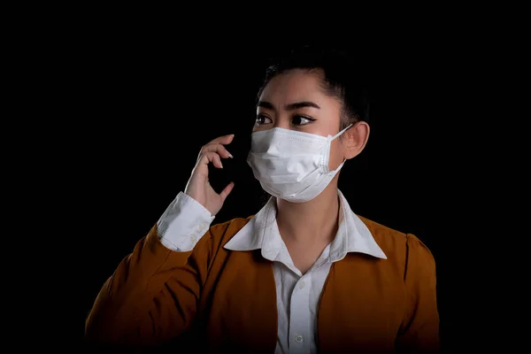 Businesswoman of young Asia woman putting on a respirator N95 mask to protect from airborne respiratory diseases as the flu covid-19 coronavirus PM2.5 dust and smog, Safety virus infection concept