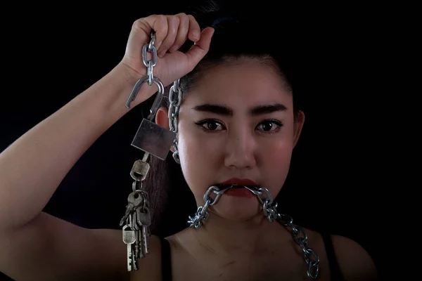 Portrait young Asia woman covered mouth by a steel chain and unlock to forbidden him the free speeching at the black background, Shut up or stop talking concept, Front view women and look at camer