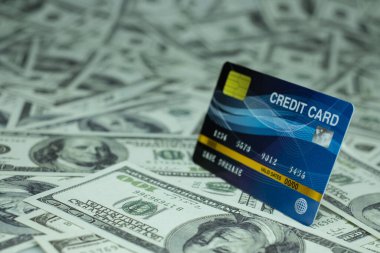 Kredi kartını kapat. 100 dolarlık banknot birikintisinden izole edilmiş.