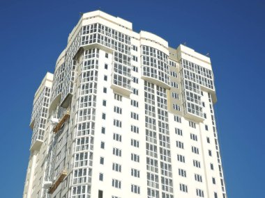 Yeni bina. Mavi gökyüzü arka planında yüksek katlı bir apartman. Rusya, Saratov - Kasım 2019