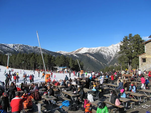 Viele Snowboarder und Skifahrer entspannen und sonnen sich unter den strahlenden Sonnenstrahlen im Skigebiet. andorra, andorra la vella-dezember, 2011 — Stockfoto