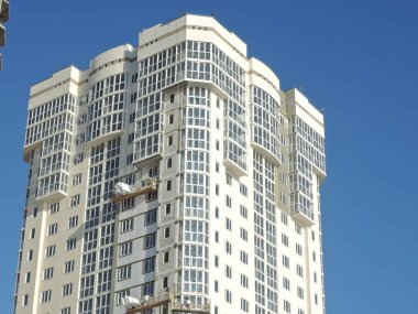 Yeni bina. Mavi gökyüzü arka planında yüksek katlı bir apartman. Rusya, Saratov - Kasım 2019