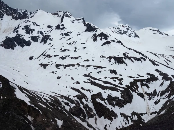 Berggipfel bei trübem Wetter mit Schnee bedeckt. — Stockfoto