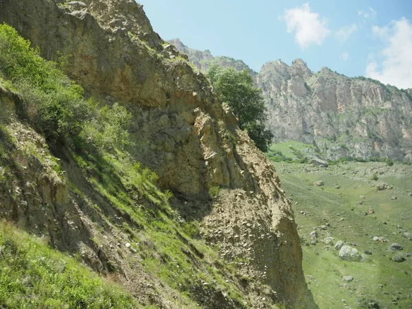 Bela paisagem com vista para as montanhas rochosas e montanhas cobertas com grama verde e arbustos — Fotografia de Stock