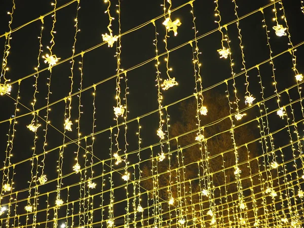 Золотой дождь рождественских украшений, свисающих с неба, на новогодние и рождественские уличные украшения — стоковое фото