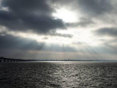 Güneş ışınları bulutların arasından geçer ve nehri aydınlatır. Buz nehirden iner..