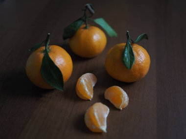 Tatilden önce ahşap bir masada taze yıkanmış mandalinalar.