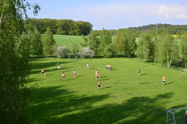 德国波茨坦- 2013年5月8日:玩乐的朋友在公园跑步和踢球. 快乐的朋友在一起度过时光。 一起踢足球。 休闲概念 — 图库照片