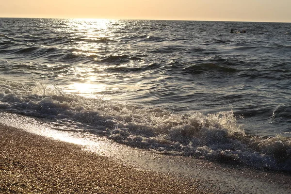 Бризки хвиль на пляжі морського узбережжя на заході сонця — стокове фото